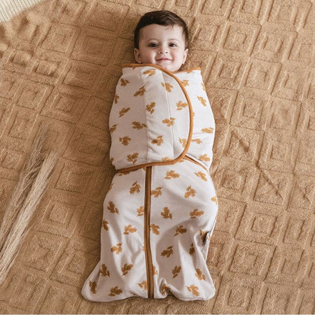 Bébé souriant emmailloté gigoteuse swaddle motif feuilles orange RemovableSack - Bébé Lova