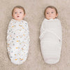 Bébé allongé dans une gigoteuse enveloppante beige en coton sur un lit bébé gris - Bébé Lova