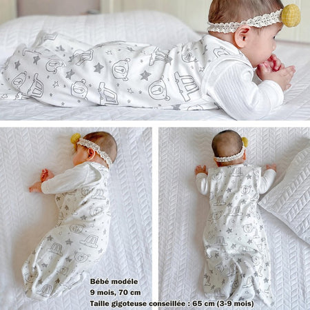 Bébé de 9 mois portant la gigoteuse été en coton motif ourson sur lit blanc - Bébé Lova