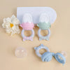 Grignoteurs de fruits en silicone rose et vert avec leur capuchon de protection transparent - Bébé Lova