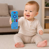 Bébé tenant une télécommande sensorielle en silicone bleu conçue pour l’éveil et la dentition - Bébé Lova