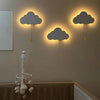 Trois lampes murales nuage lumineuses installées au-dessus d’un lit bébé - Bébé Lova