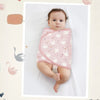 Bébé emmailloté dans un lange à motif cygnes rose, présenté dans un cadre photo décoratif - Bébé Lova