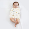 Bébé emmailloté dans un lange à motif chiens sur fond crème - Bébé Lova