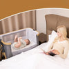 Maman lisant à côté d’un lit bébé cododo 3-en-1 avec bébé allongé confortablement - Bébé Lova