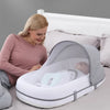 Maman utilisant un berceau pliable avec moustiquaire pour bébé dans une chambre - Bébé Lova