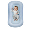 Bébé allongé dans un coussin nid bébé bleu avec rebords protecteurs doux - Bébé Lova