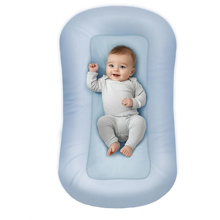 Bébé allongé dans un coussin nid bébé bleu avec rebords protecteurs doux - Bébé Lova