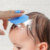 Brosse massante silicone bleue utilisée pour laver les cheveux d’un nourrisson pendant le bain - Bébé Lova