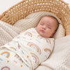 Bébé endormi emmailloté dans un lange swaddle coton avec motifs arc-en-ciel dans un panier en osier - Bébé Lova