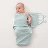 Bébé enveloppé progressivement dans un lange swaddle coton bleu clair - Bébé Lova