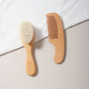 Kit brosse douce et peigne bébé en bois naturel posé sur tissu blanc - Bébé Lova