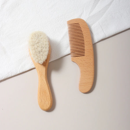 Kit brosse douce et peigne bébé en bois naturel posé sur tissu blanc - Bébé Lova