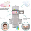 Matelas à langer AquaMom déplié : poche pour lingettes et crèmes, poche filet pour couches, coussin protège-tête et poche réversible pour mouchoirs - Bébé Lova