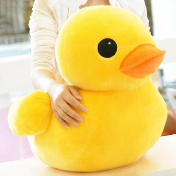 Peluche canard jaune toute douce tenue dans les bras d’une femme - Bébé Lova