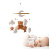 Bébé endormi sous un mobile de berceau en bois avec ours en feutre et nuages suspendus - Bébé Lova