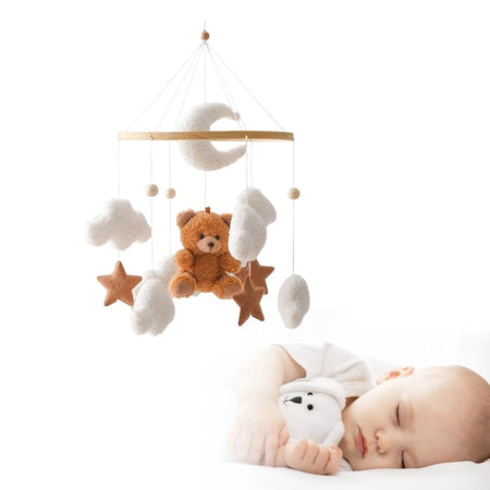 Bébé endormi sous un mobile de berceau en bois avec ours en feutre et nuages suspendus - Bébé Lova