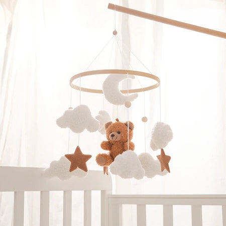Mobile de berceau en bois avec ours en feutre suspendu au-dessus d’un lit bébé - Bébé Lova
