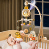 Bébé souriant sous un mobile berceau projecteur avec veilleuse et télécommande dans une chambre de nuit - Bébé Lova