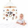 Mobile en bois Bellwood au-dessus d’un bébé endormi avec lumières tamisées - Bébé Lova