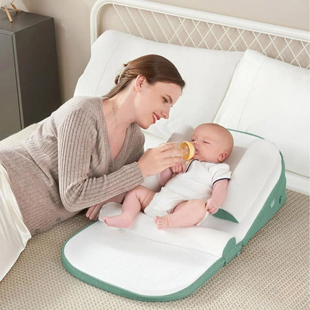 Maman donnant le biberon à bébé installé sur l'oreiller anti-reflux - Bébé Lova