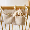 Organiseur de lit beige suspendu à un berceau en bois avec doudou lapin et tétine - Bébé Lova