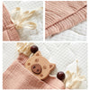 Gros plans sur les finitions de l'organiseur : nouettes, tissu gaze de coton et poche avec jouet en bois - Bébé Lova