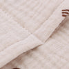 Gros plan sur le tissu en gaze de coton beige de l'organiseur de lit - Bébé Lova