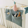 Organiseur de lit vert sauge suspendu à un berceau avec jouets et poire en tricot - Bébé Lova