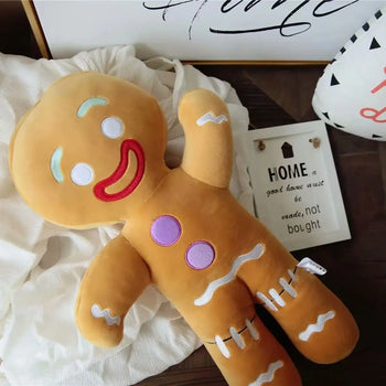 Peluche bonhomme pain d’épices géante allongée sur un lit avec décoration cosy - Bébé Lova