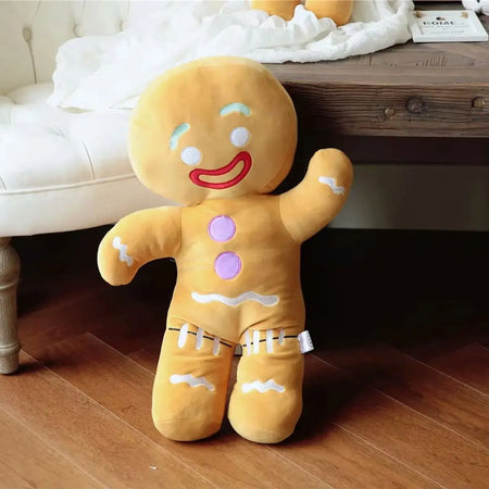 Grande peluche pain d’épices souriante posée au sol dans une chambre enfant - Bébé Lova