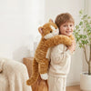 Enfant souriant portant une peluche chat à bras longs autour du cou pour des câlins réconfortants - Bébé Lova