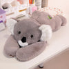 Peluche koala grise à bras longs posée sur un bureau dans une chambre enfant - Bébé Lova
