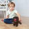 Petit garçon jouant calmement avec une peluche monstre kawaii Funny Domo dans un salon - Bébé Lova