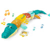 Peluche musicale hochet bébé crocodile MusicGator sur fond blanc avec notes de musique décoratives - Bébé Lova