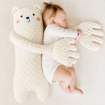 Peluche ours tapotante télécommandée entourant bébé allongé pour un effet rassurant - Bébé Lova