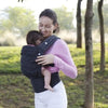 Maman portant son bébé contre elle avec le porte-bébé ergonomique ErgoLova - Bébé Lova