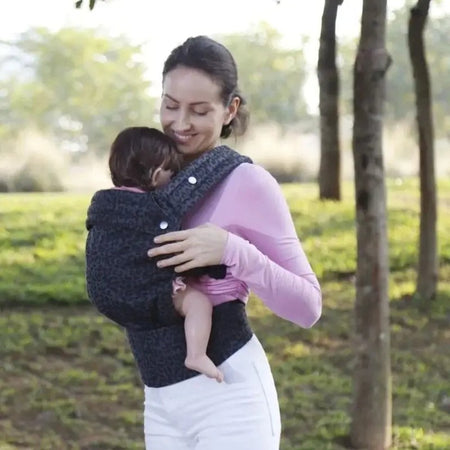 Maman portant son bébé contre elle avec le porte-bébé ergonomique ErgoLova - Bébé Lova