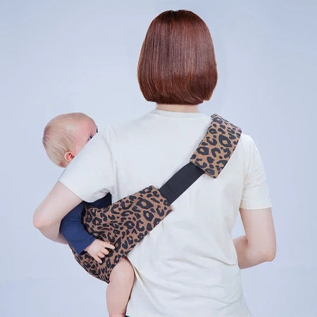 Vue de dos du portage sur la hanche avec le porte-bébé léopard LeoParry et sa sangle croisée - Bébé Lova