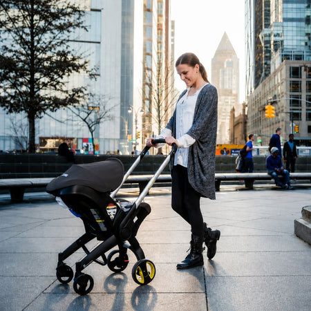Femme poussette QuadPram mode cosy noir rue urbaine moderne - Bébé Lova