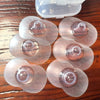 Six protège-mamelons en silicone de différentes tailles avec leur boîte sur une table en bois - Bébé Lova