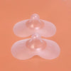 Deux protège-mamelons en silicone transparent posés sur fond orange - Bébé Lova