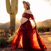 Femme enceinte portant une robe rouge élégante près d’un cactus pendant une séance photo maternité - Bébé Lova