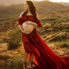 Future maman en robe rouge fluide posant dans un paysage désertique au coucher du soleil - Bébé Lova