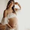 Femme enceinte souriante portant une robe blanche fluide dans un intérieur lumineux - Bébé Lova