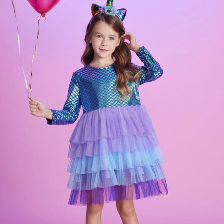 Robe sirène MermailTull portée avec serre-tête licorne et ballon rose sur fond pastel - Bébé Lova