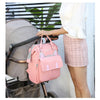 Sac à dos à langer rose suspendu à une poussette pour les sorties bébé - Bébé Lova