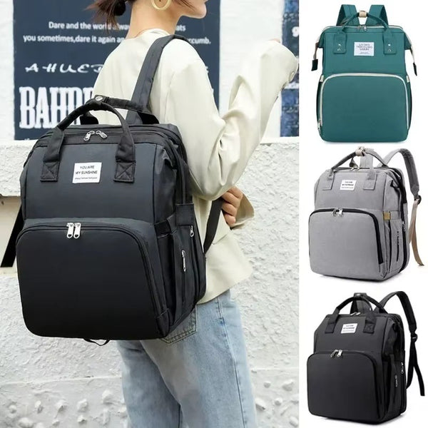Femme portant le sac à langer noir en sac à dos, décliné en vert, gris et anthracite - Bébé Lova
