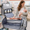 Maman avec son bébé en magasin et sac à langer gris déplié en lit, disponible en plusieurs coloris - Bébé Lova