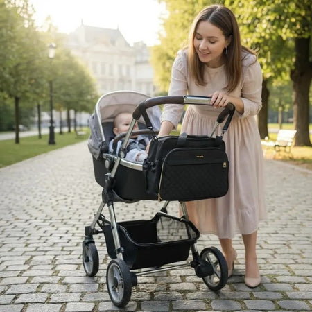 Maman en promenade avec le sac à langer bandoulière CrossMom noir accroché à la poussette - Bébé Lova